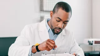 Man in lab coat fixing a Vantive product
