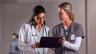 Healthare professionals look at a tablet 