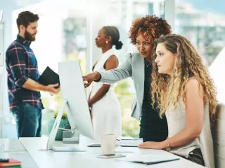 A diverse team collaborating on a computer, engaged in productive work