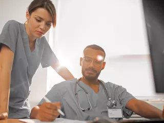  A nurse and a doctor collaborating on a computer