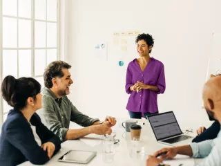 A woman presenting to colleagues in a conference room