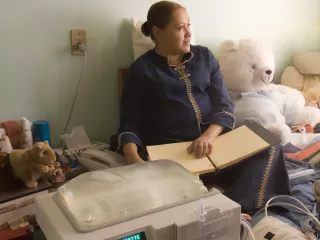 A women sits next to Homechoice, Vantive's automated peritoneal dialysis (APD) system